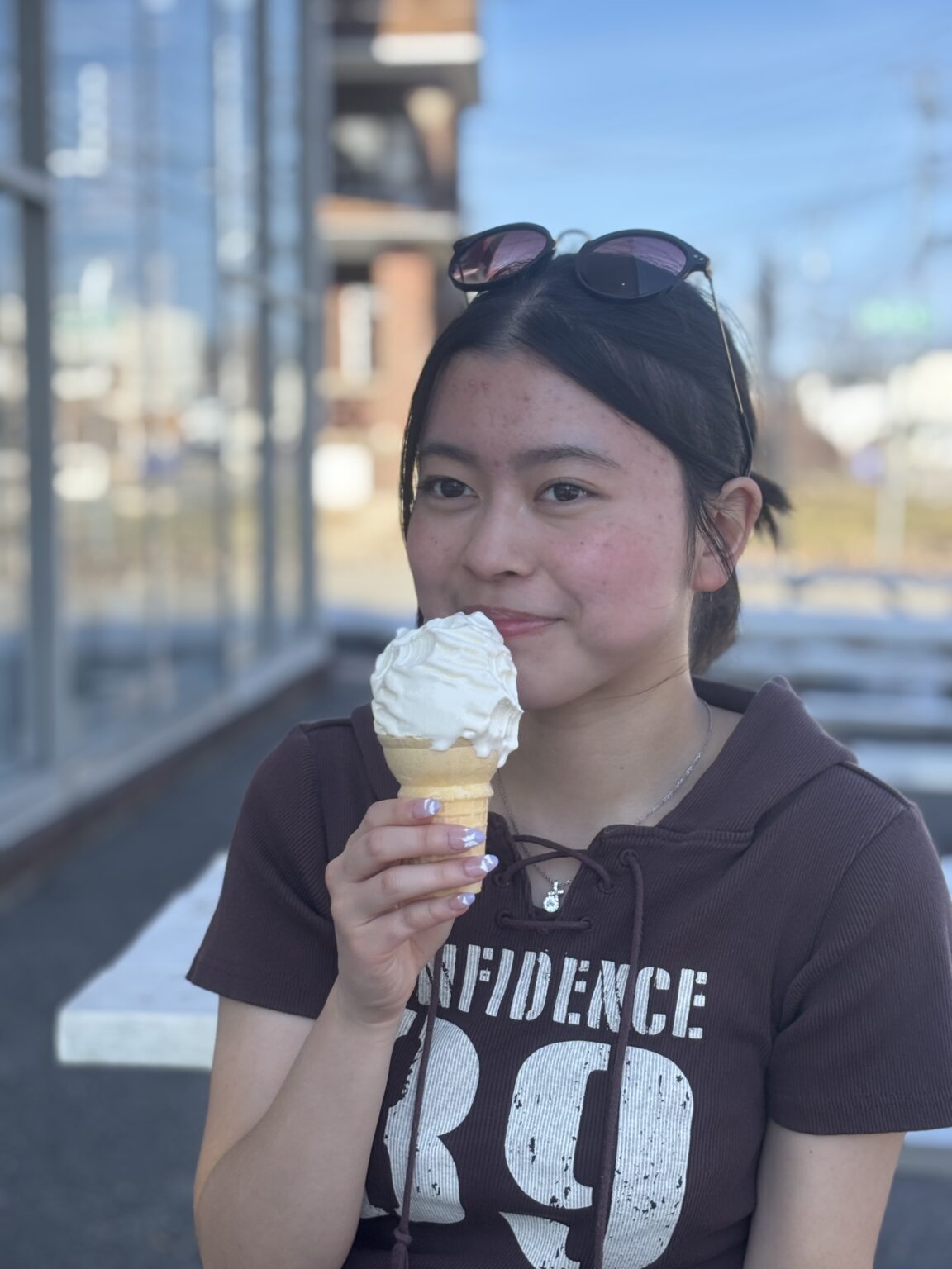 International student smiling with an ice cream cone outdoors during a break from boarding school