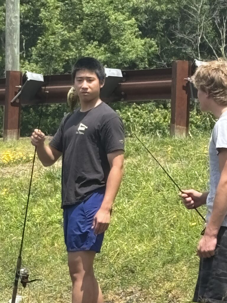 Boarding school student goes fishing with a friend during a summer break homestay