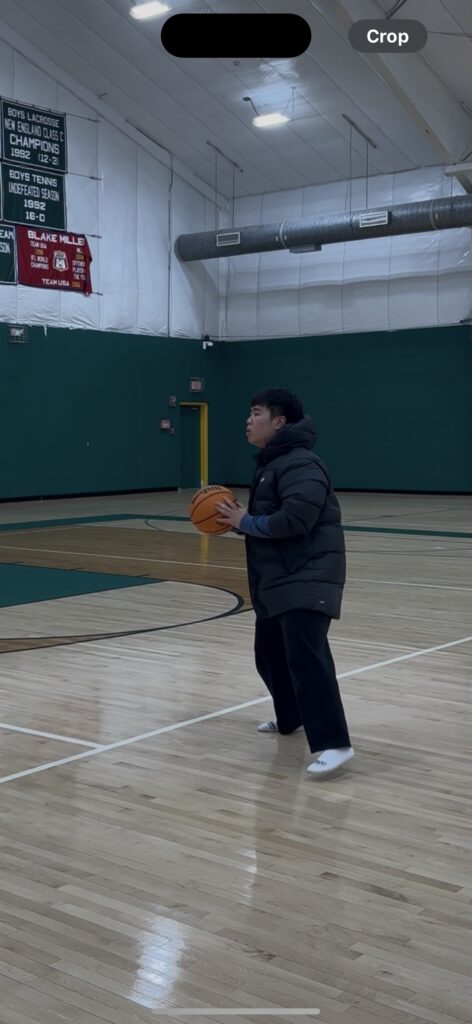 Ian holding a basketball in an indoor gym