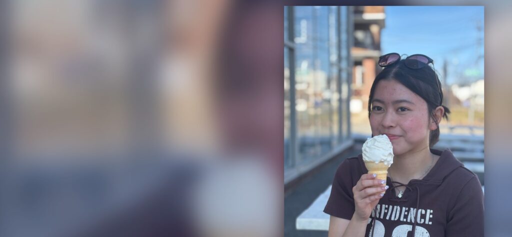 International student smiling with an ice cream cone outdoors during a break from boarding school